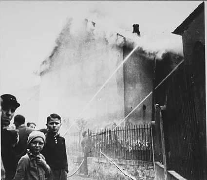 As the synagogue in Oberramstadt burns during Kristallnacht (the "Night of Broken Glass"), firefighters instead save a nearby house.
