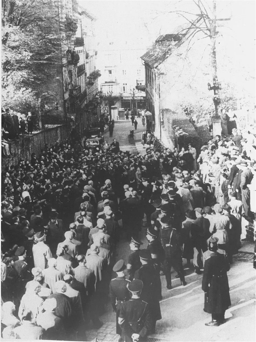 After the Kristallnacht ("Night of the Broken Glass") pogrom, German civilians line the streets to watch the forced march of Jewish ...