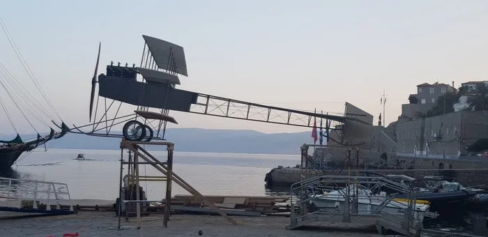 Το ομοίωμα του πρωτοπόρου ανεμοπλάνου - υδροπλάνου του ατρόμητου Υδραίου Καμπέρου (που πήρε το ψευδώνυμο "τρελλοκαμπέρος") δια χειρός του μεγάλου δάσκαλου, ζωγράφου και σκηνογράφου, Νίκου Στεφάνου, στο λιμάνι της ΄Υδρας