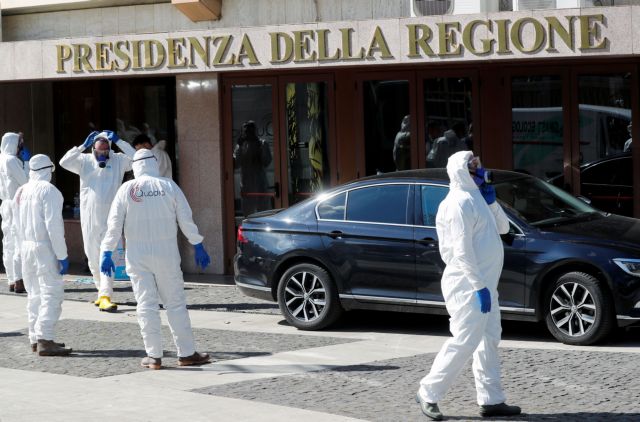 Workers dressed in protective garments prepare to sanitise a regional building as Italy seeks to contain a coronavirus outbreak in Rome